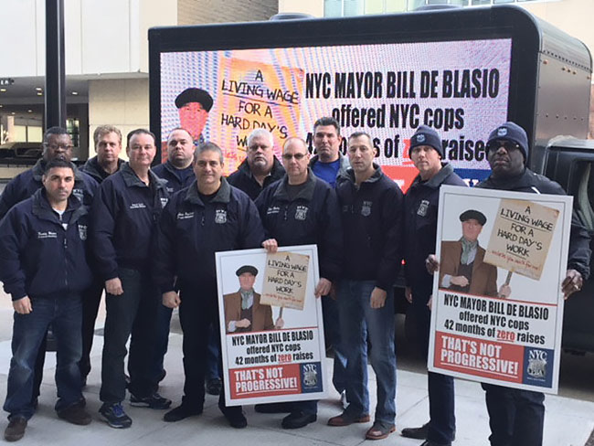 DEFINITELY NOT OUR GUY: Members of the Patrolmen’s Benevolent Association went to Des Moines, Iowa, Dec. 19 to shadow Mayor de Blasio during a visit in which he addressed a group of progressive Democrats. Using picket signs and a mobile billboard, union members cited his reluctance to give meaningful raises to police officers as a sign that he’s not really a progressive.